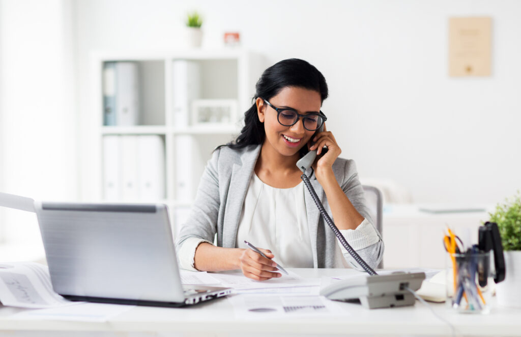 happy businesswoman calling on phone at office